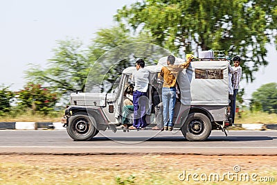 People in an old indian truck driving on a highway