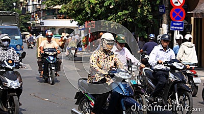 People ride motorbikes on busy road in Hanoi