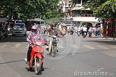 People ride motorbikes on busy road in Hanoi