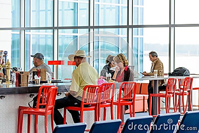 People seated at restaurant bar in an airport