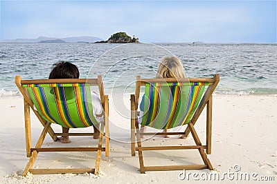 People sitting on chairs at the beach