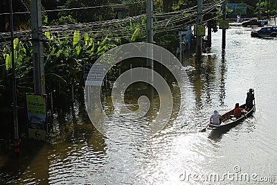 People travel by boat on the road during flood