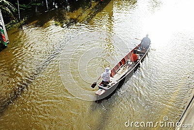 People travel by boat on the road during flood