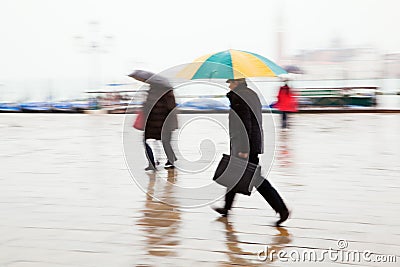 People with umbrellas on the move