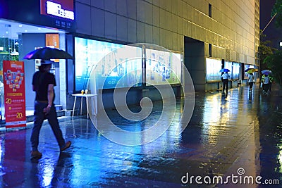 People walking in rain at night