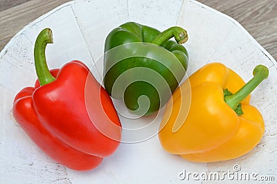 Peppers in three colors on a white natural plate
