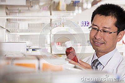 Pharmacist taking down and examining prescription medication in a pharmacy