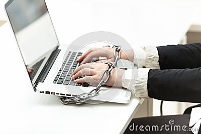 Photo of businesswoman locked to laptop by chain
