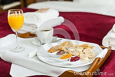 Photo of tray with breakfast food on the bed
