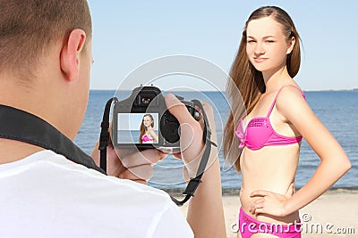 Photographer with camera taking picture of beautiful woman on th