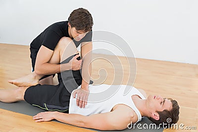 Physical therapist examining young mans leg