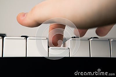 Piano keys and human finger