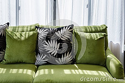 Pillows on modern green sofa