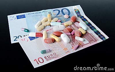 Pills, tablets and capsules spread on banknotes