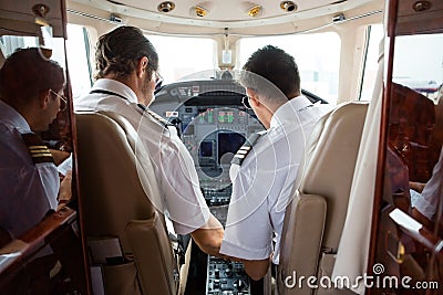 Pilot And Copilot In Cockpit Of Corporate Jet
