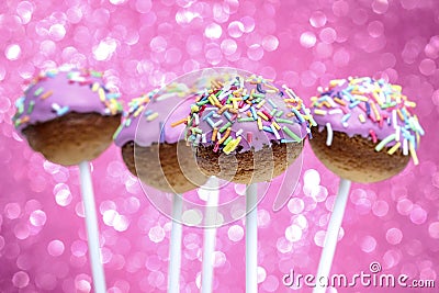 Pink cake pops decorated with colorful sprinkles