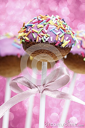 Pink cake pops decorated with colorful sprinkles