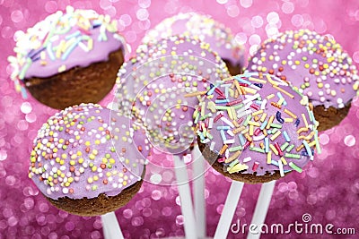 Pink cake pops decorated with colorful sprinkles