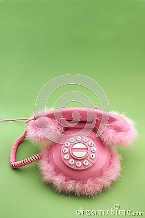 Pink retro phone with copy space on green background