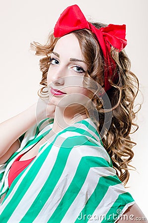 Pinup girl beautiful young woman with red lips and a bow on her head looking at the camera closeup portrait picture