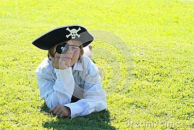 Pirate boy lying on grass