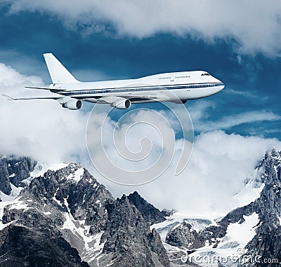 Plane flying over the snow-capped mountains.