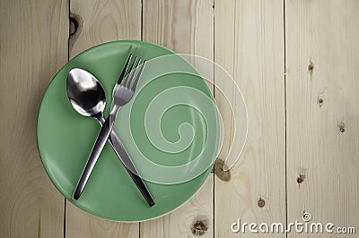 Plate and cutlery on wooden table