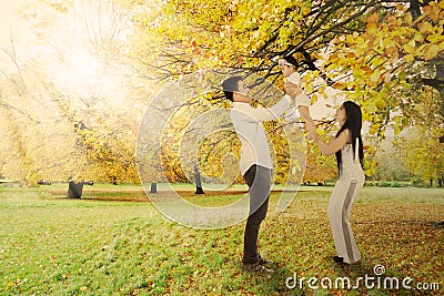 Playful family under autumn tree