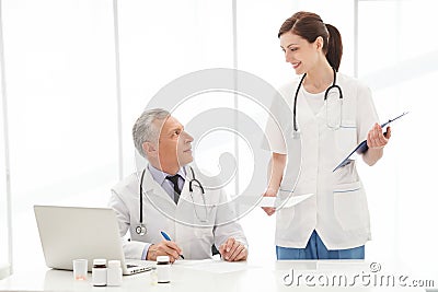 Please, sign here. Two medical colleagues looking at each other