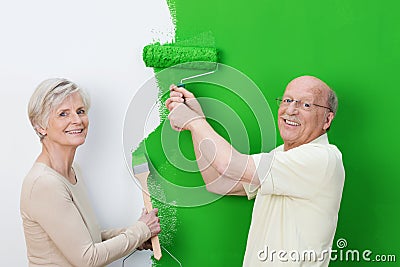 Pleased senior couple showing off the new paint