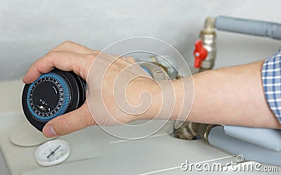 Plumber adjusting the clock on the boiler