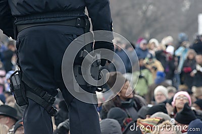 Police with gun guards crowd