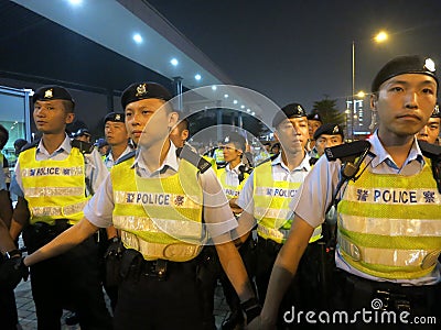 Chinese Police Officers Hold Back Crowd at a Prote