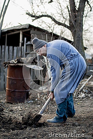 Poor and old romanian man working his land in a traditional way with empty hands