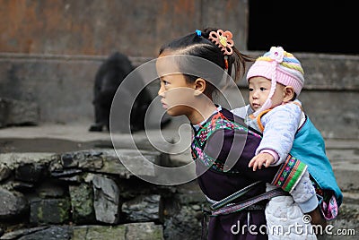 Poor traditional girl who care kid in the old village in China