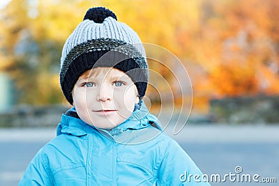 Portrait of adorable toddler boy in warm winter clothes on cold