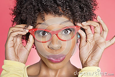 Portrait of an African American woman wearing retro style glasses over colored background