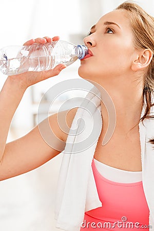 Portrait of attractive young woman drinking water at gym