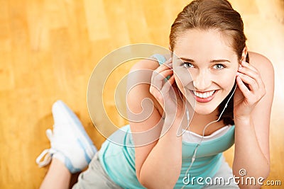 Portrait of attractive young woman listening to music at gym