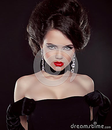 Portrait of beautiful brunette woman with red lips over dark