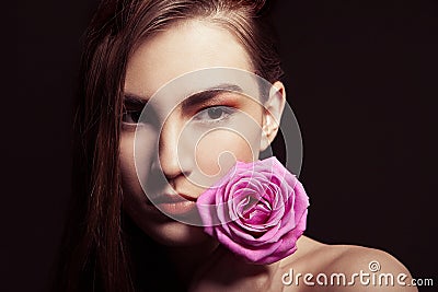 Portrait of beautiful brunette woman with rose