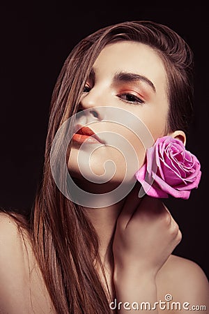 Portrait of beautiful brunette woman with rose