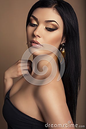 Portrait of beautiful woman with gold makeup