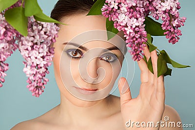 Portrait of beautiful woman with makeup and branch of lilac