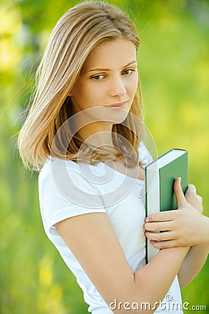 Portrait of beautiful young blond woman with book