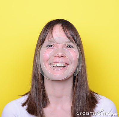 Portrait of beautiful young woman smiling against yellow backgro