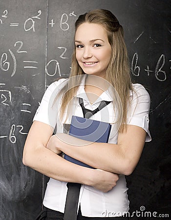 Portrait of beauty happy student with books near blackboard