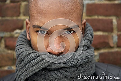Portrait of a black male fashion model with gray scarf covering face