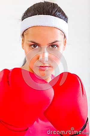 Portrait of concentrated fit girl in boxing gloves