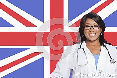 Portrait of confident mixed race female surgeon over British flag